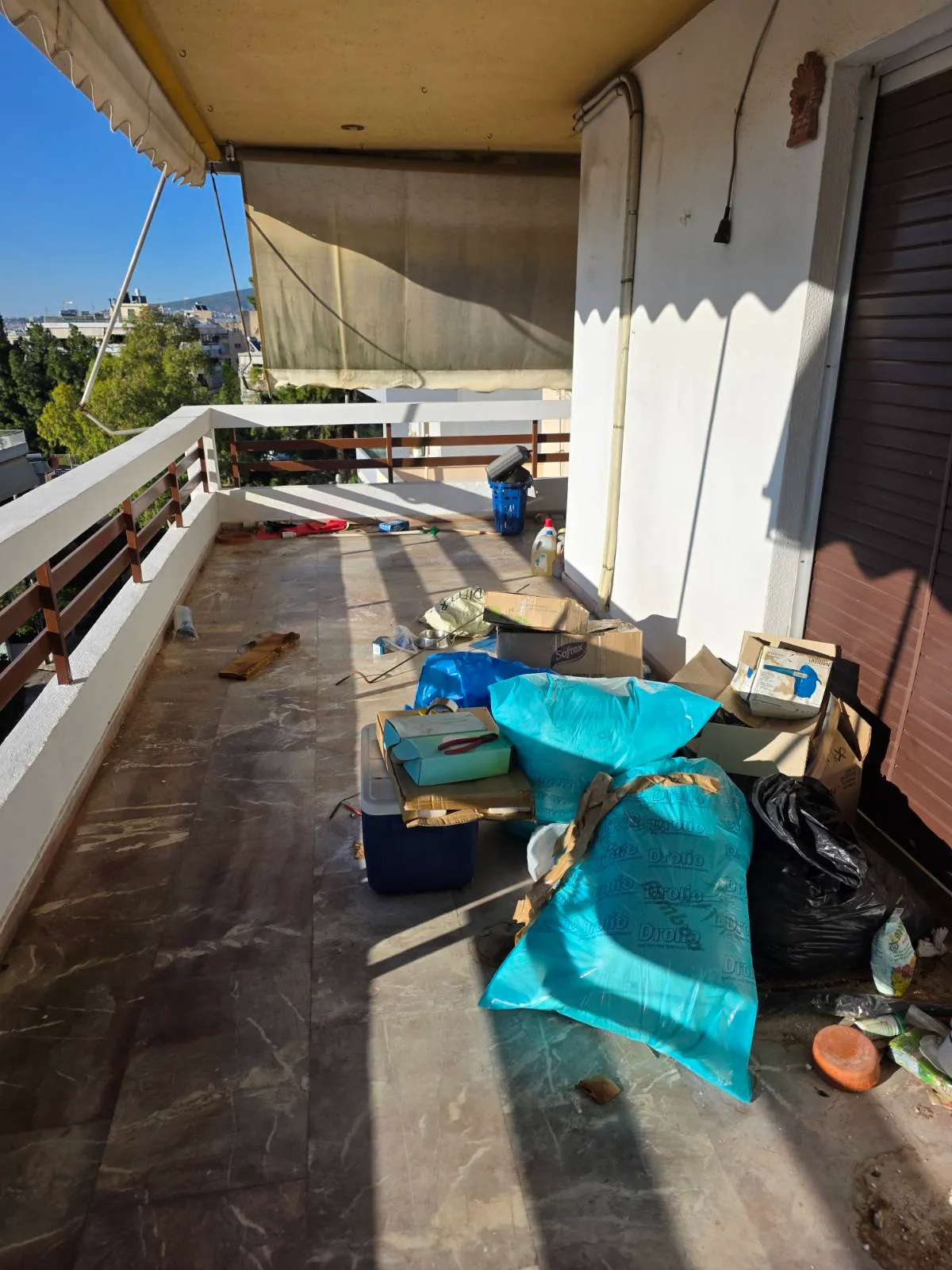 Πριν την αποκομιδή μπαζών – μπαλκόνι διαμερίσματος γεμάτο σακούλες και κούτες